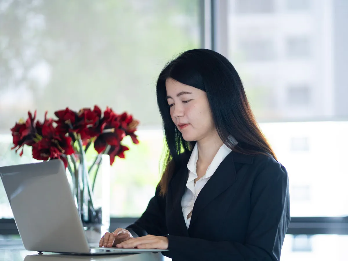A business professional working through company documents on a laptop